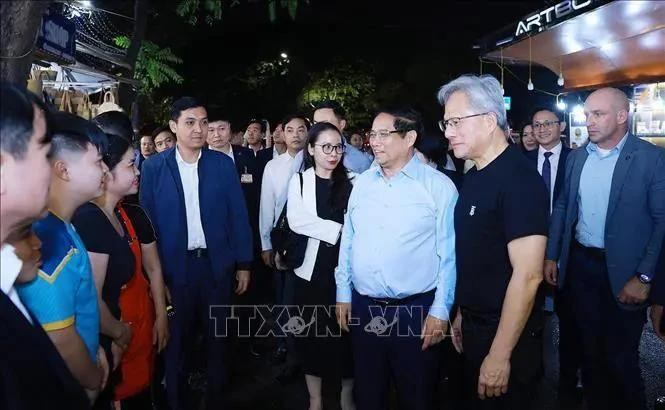Le Premier ministre vietnamien Pham Minh Chinh (2e de droite à gauche) et le président-directeur général de NVIDIA Jensen Huang (droite) rencontre des habitants de Hanoï jeudi soir. Photo : VNA.
