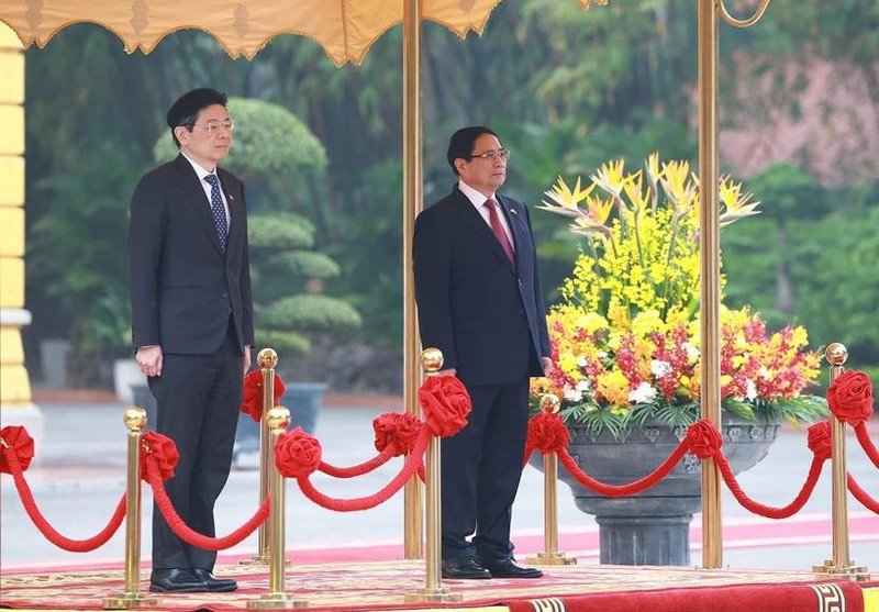Le Premier ministre vietnamien Pham Minh Chinh (à droite) a présidé, le matin du mercredi 26 mars à Hanoï, la cérémonie d’accueil officielle en l’honneur de son homologue singapourien, Lawrence Wong en visite officielle au Vietnam les 25 et 26 mars. Photo : VNA.