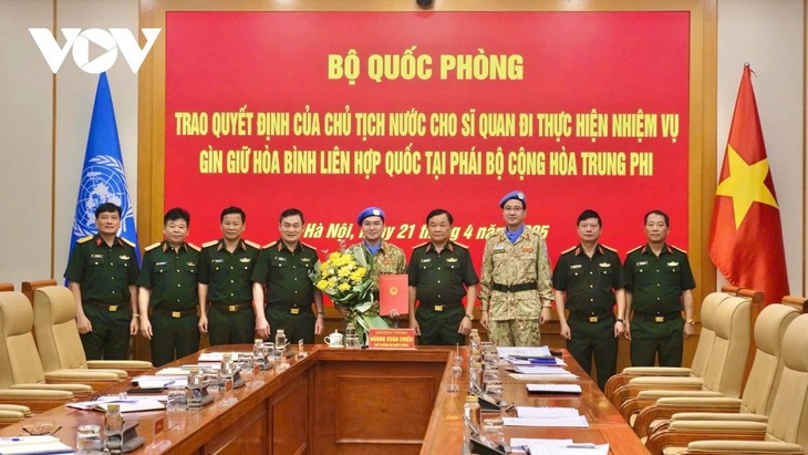 Le général Hoàng Xuân Chiên, vice-ministre de la Défense remet au major Su Tân Phi Long la décision présidentielle officialisant son déploiement à la mission de maintien de la paix en Afrique centrale. Photo : VOV.