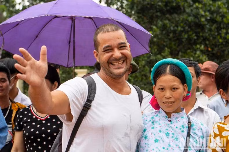 Un touriste étranger participe avec enthousiasme aux activités culturelles avec la population locale.