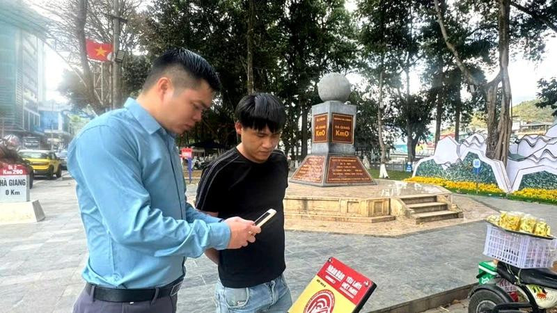 Un touriste s'enregistre au kilomètre 0, ville de Hà Giang. Photo : NDEL.