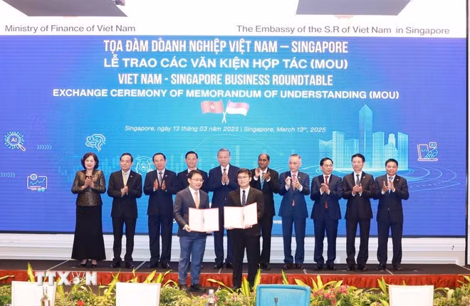 Le secrétaire général Tô Lâm (5e de gauche à droite) assiste à l'échange de documents de coopération entre les entreprises des deux pays. Photo : VNA.