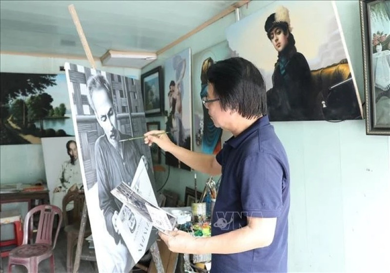 L'artiste Tran Hoa Binh peint le portrait de l'Oncle Ho. Photo : VNA.