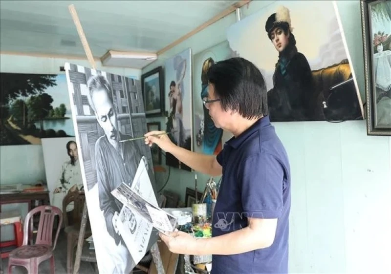 L'artiste Tran Hoa Binh peint le portrait de l'Oncle Ho. Photo : VNA.