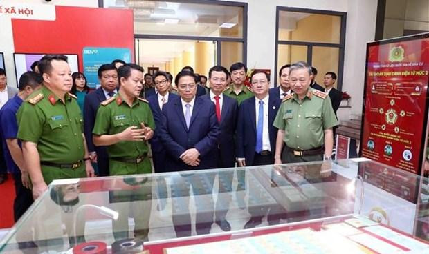 Le Premier ministre Pham Minh Chinh examinant des produits transformation numérique en exposition en marge de la conférence. Photo : VNA.