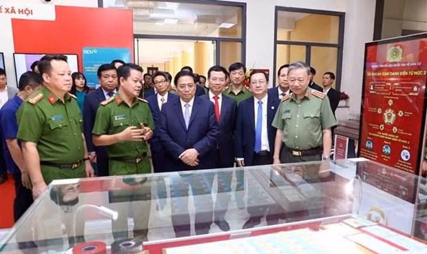 Le Premier ministre Pham Minh Chinh examinant des produits transformation numérique en exposition en marge de la conférence. Photo : VNA.