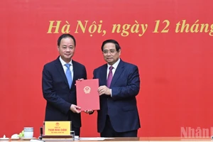 Le Premier ministre Pham Minh Chinh remet la décision à Tran Hong Thai pour sa nomination à la présidence de l'Académie. Photo : NDEL