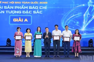 Le Quoc Minh, rédacteur en chef du journal « Nhân Dân », vice-président de la Commission centrale de la propagande et de la mobilisation des masses du Parti et président de l’Association des journalistes du Vietnam, remet les prix A aux auteurs. Photo : NDEL