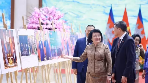 Le Premier ministre Le Minh Hung et le président de l'Assemblée nationale cambodgienne, Samdech Khuon Sudary, visitent une exposition de photographies illustrant la coopération entre les deux pays, organisée par l'Agence vietnamienne d'information (VNA). Photo : VNA.