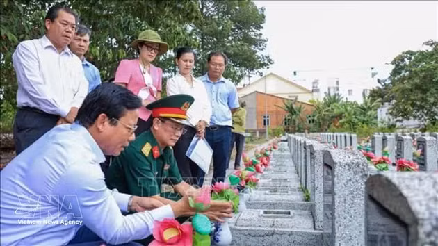 Le vice-président du Comité populaire de la province de Tay Ninh, Pham Tan Hoa (gauche, assisse), accompagné d'une délégation, examine les informations sur les tombes des martyrs non identifiés au cimetière des martyrs d'An Tinh, quartier d'An Tinh, province de Tay Ninh. Photo : VNA.