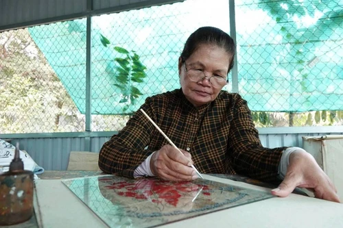 À Phuoc Thuan, les peintures sur verre sont réalisées à l’aide de fins pinceaux, puis laissées à sécher avant d’être mises en couleur. Photo : VOV.