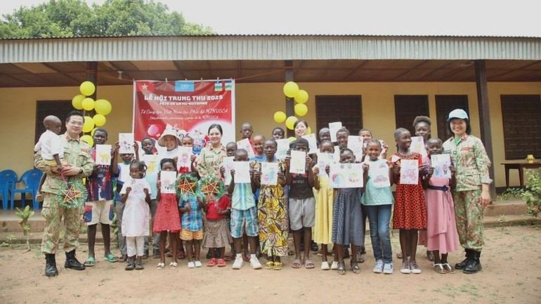 Les Casques bleus vietnamiens prennent une photo souvenir avec les enfants du Foyer de charité à Bangui. image-3.jpg