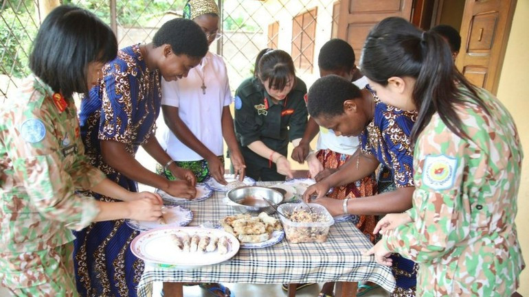 Les membres du contingent vietnamien également initient les enfants et les habitants de Bangui à la préparation des galettes de riz pour nems. image-2.jpg