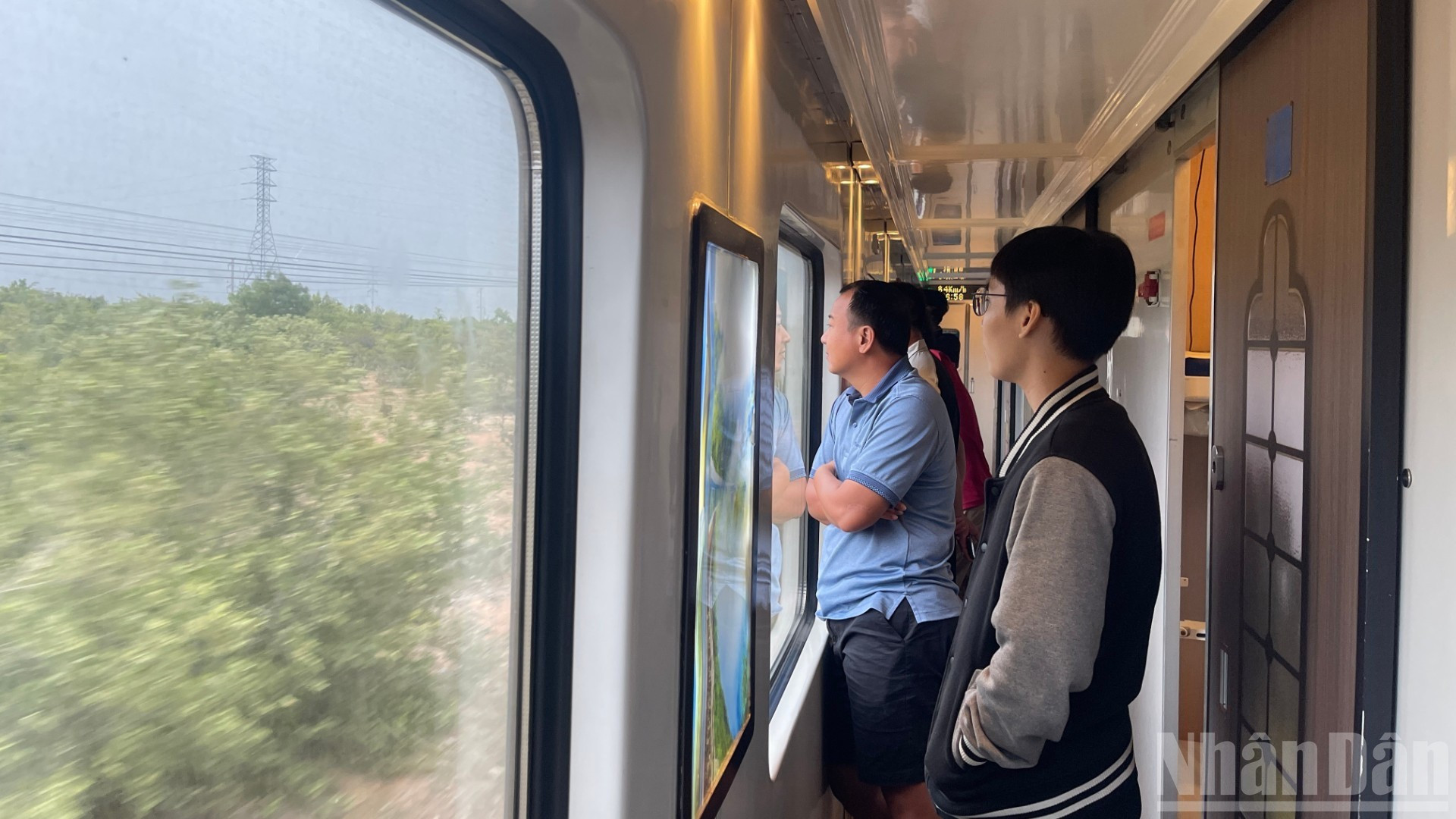 Les passagers admirent le paysage défilant à travers la fenêtre du train, savourant un voyage paisible et empreint de sérénité. Photo : NDEL. image-3.jpg