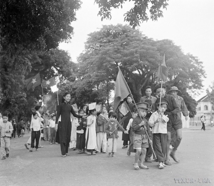 Les enfants de Hanoï, accompagnés de leurs familles, brandirent des drapeaux pour accueillir les soldats libérateurs. Photo d’archives/VNA. image-19.jpg