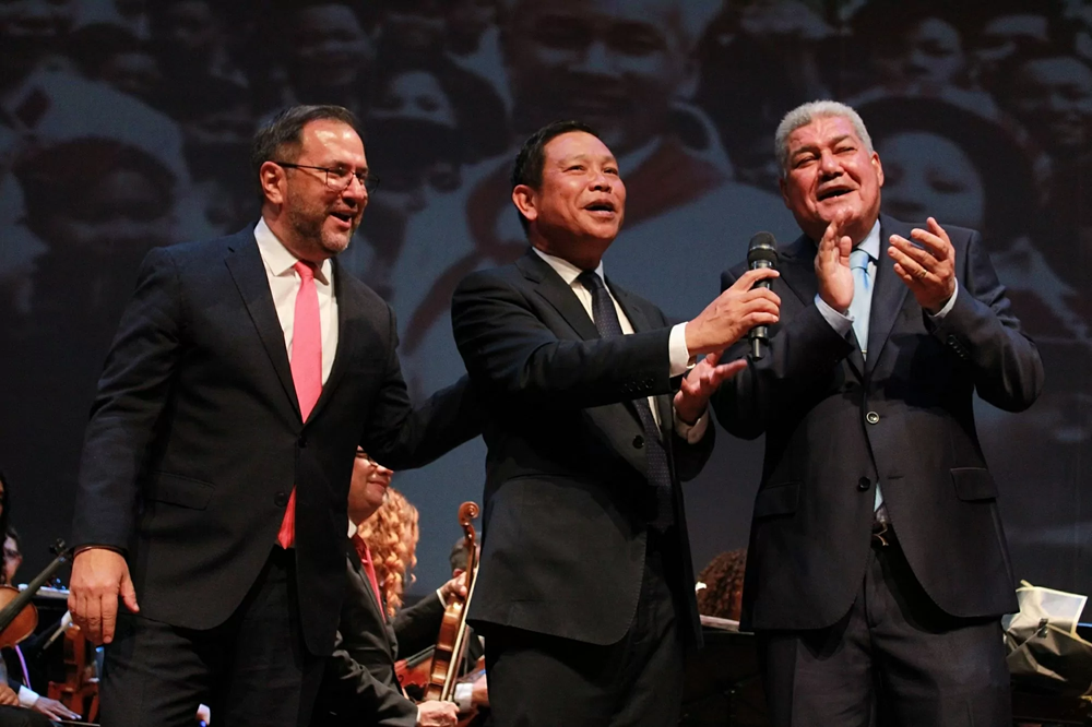 Le ministre vénézuélien des Affaires étrangères, Yvan Gil, l’ambassadeur du Vietnam, Vu Trung My, et le vice-président du Parti socialiste unifié du Venezuela (PSUV), Eduardo Pinera, entonnent ensemble la chanson “Comme si l'Oncle Hô était encore présent le jour de la grande victoire” lors du spectacle artistique spécial “Pour toujours Hô Chi Minh”. Photo : ambassade du Vietnam au Venezuela. btng-yvan-gil-trai-va-pho-chu-tich-psuv-eduardo-pinera-cung-hat-bai-nhu-co-bac-trong-ngay-vui-dai-thang-120250821072324.png