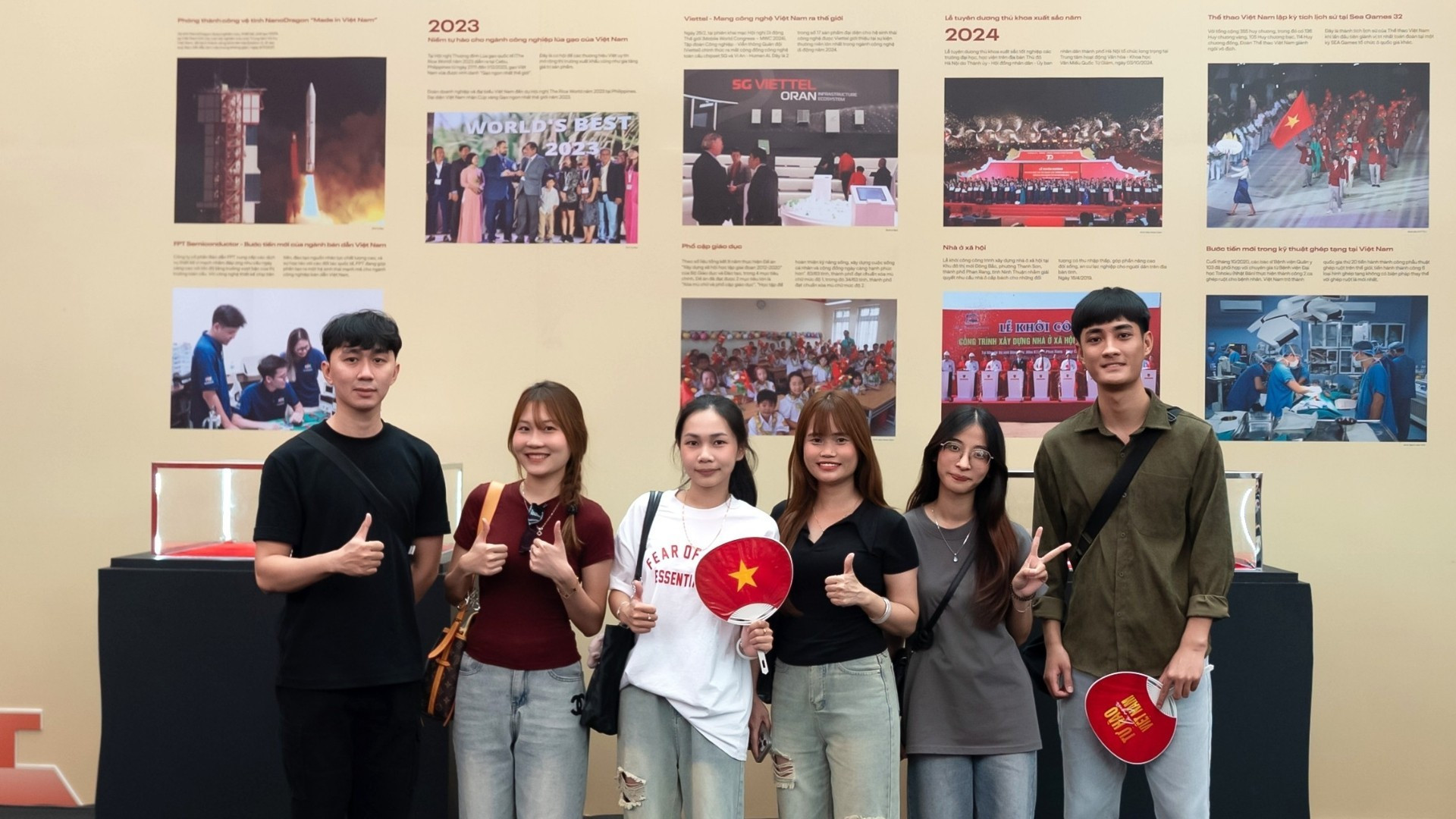 Les jeunes prennent des photos souvenirs dans l’espace de l’exposition « 95 ans sous la lumière du drapeau du Parti ». Photo : NDEL.