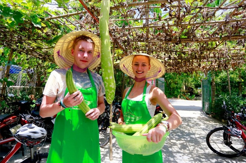 Des touristes étrangers découvrent les produits agricoles locaux lors d’un circuit à vélo à Hue. Photo : Thuong Hien/Vneconomy. 7587.jpg