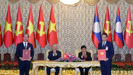 Le secrétaire général To Lam et le secrétaire général du PPRL et président lao, Thongloun Sisoulith, supervisent l’échange des accords de coopération entre les deux pays. Photo : VNA.