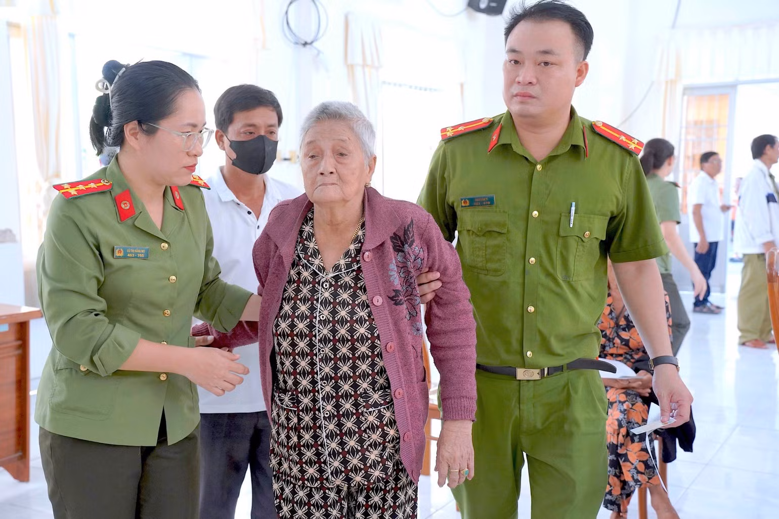 Des policiers de la commune de Tan Tien, province de Ca Mau, aident des proches âgés de soldats tombés pour la Patrie à se rendre au point de collecte pour fournir des échantillons biologiques destinés aux analyses ADN. Photo : HUU DE.