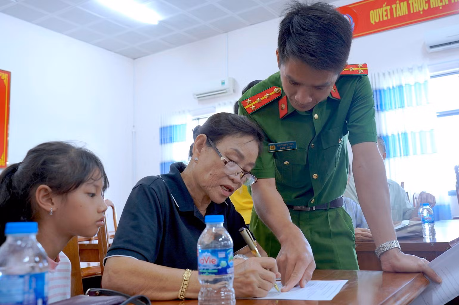 Des policiers des communes et des quartiers de Ca Mau accompagnent les familles dans le remplissage des formulaires et la vérification des informations avant le prélèvement des échantillons d’ADN. Photo : HUU DE.