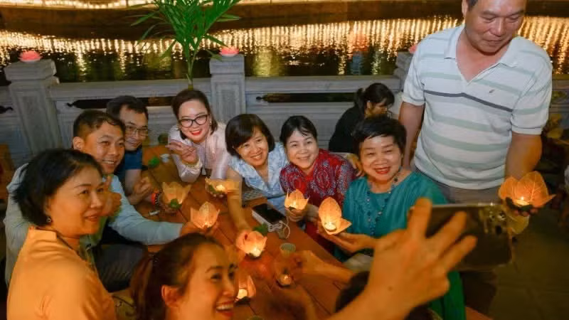Les participants confectionnent avec enthousiasme des lanternes flottantes. (Photo : Bao Long)