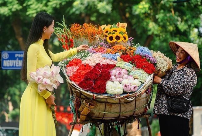 Les vendeuses ambulantes portant des paniers de fleurs sont l’un des symboles les plus caractéristiques de l’automne hanoïen. Photo: VNA anh-2.jpg