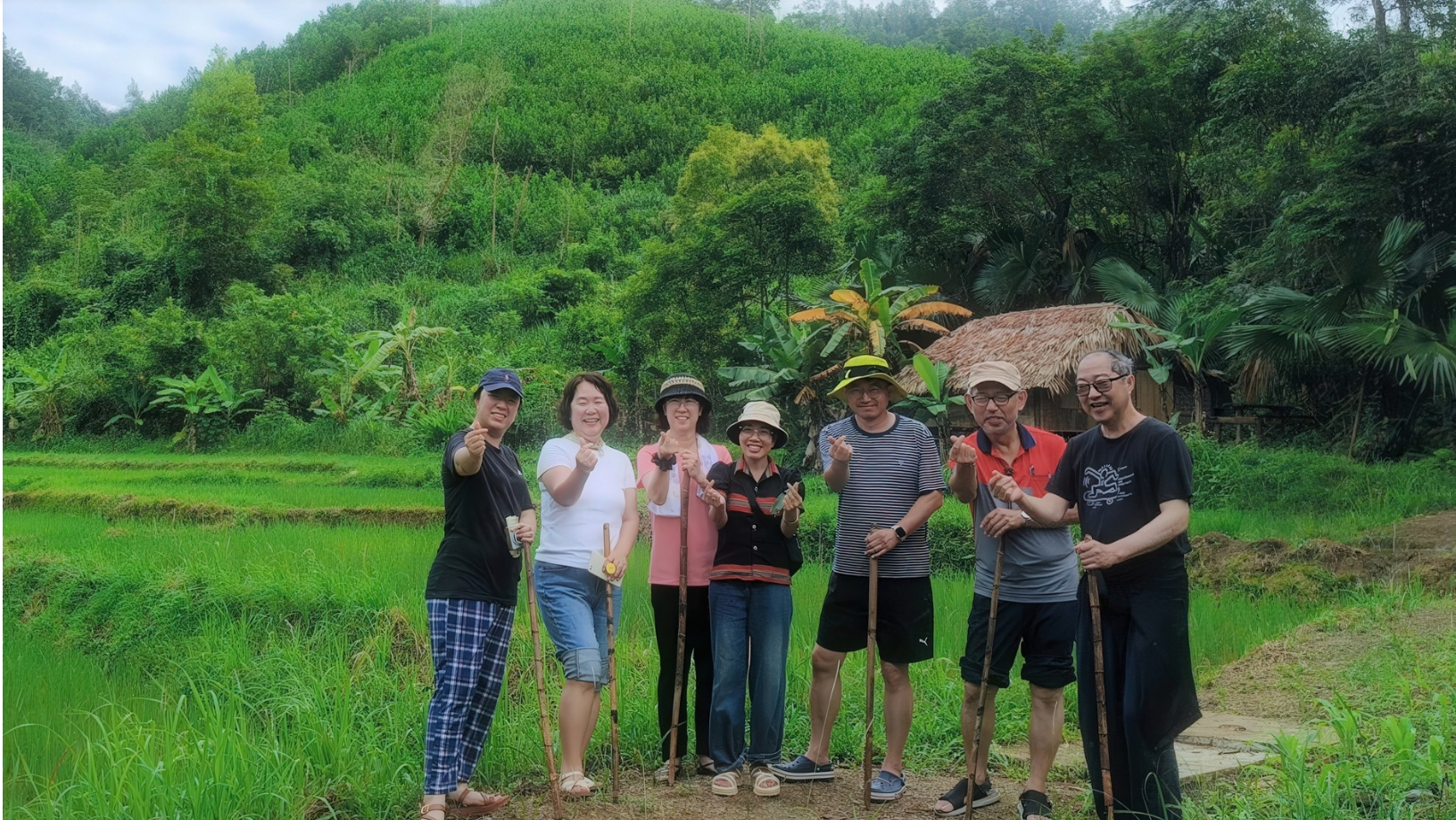 Thin (au centre) guide un groupe de visiteurs à travers le village touristique de Bhơ Hôồng. 2.png