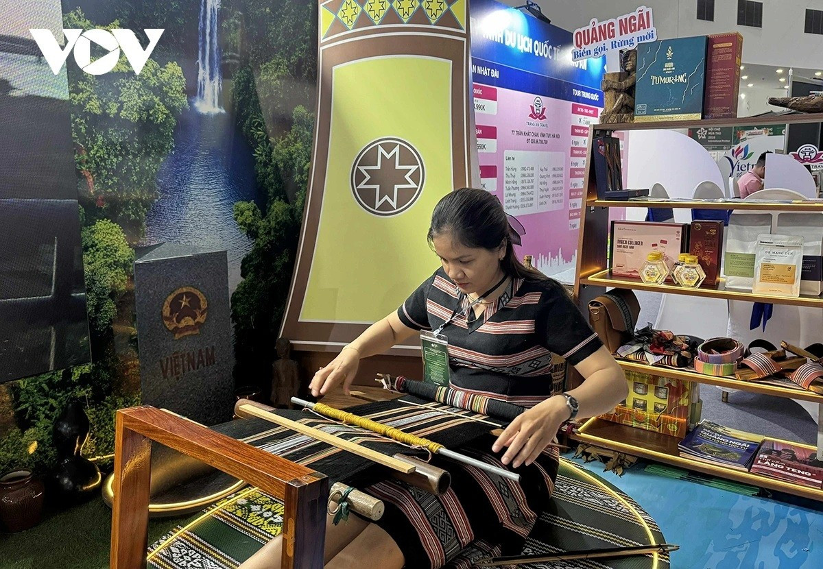 Mme Pham Thị Y Hoa montre aux visiteurs le processus de tissage du brocart de Lang Teng. n5.jpg