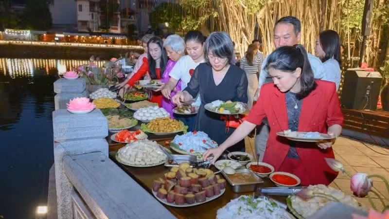 Des visiteurs dégustent des plats végétariens dans une atmosphère paisible. (Photo : Bao Long)