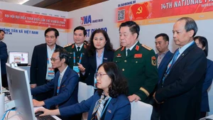 Le général Nguyen Trong Nghia visite la zone de travail de l'Agence vietnamienne d'information au Centre de presse du XIVe Congrès national du Parti. Photo : VNA.