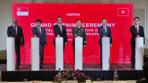 Le général de corps d'armée Hoang Xuan Chien, membre de la Permanence de la Commission militaire centrale et vice-ministre de la Défense (3e de droite à gauche), et d'autres délégués, appuient sur le bouton inaugurant le bureau de représentation de Viettel à Singapour. Photo: VNA.