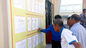 Des électeurs issus des minorités ethniques de la commune de Bac Binh (Lâm Dông) consultent les biographies des candidats avant le jour du scrutin. Photo : VNA.