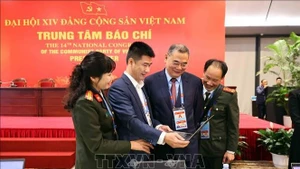 Des reporters travaillent au Centre de presse du XIVe Congrès national du Parti. Photo : VNA.