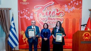 L’ambassadrice Pham Thi Thu Huong remet le 11e Prix national de l’information pour l'étranger aux amis grecs. Photo : VNA.