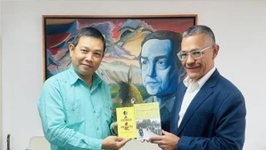 L'ambassadeur vietnamien Vu Trung My (gauche) offre au ministre de la Culture Ernesto Villegas plusieurs œuvres représentatives du Président Ho Chi Minh. Photo : VNA.