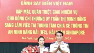 Le général de division Vu Trung Kien, commandant adjoint chargé des affaires juridiques de la Garde-côte du Vietnam, remet la décision à la lieutenante Tran Thi Minh Hang. Photo : La Duy.