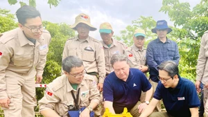 Le vice-ministre des Affaires étrangères, Do Hung Viet, et l’ambassadeur des États-Unis au Vietnam, Marc E. Knapper, appuient sur le bouton de mise à feu pour la destruction de bombes et mines à la commune de Huong Tan, district de Huong Hoa, province de Quang Tri, le 2 avril 2025. Photo : VNA.