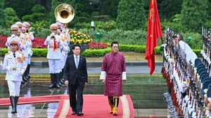 Le président vietnamien Luong Cuong et le roi du Bhoutan Jigme Khesar Namgyel Wangchuck passent en revue la garde d'honneur de l'Armée populaire vietnamienne lors de la cérémonie d'accueil. Photo: NDEL.