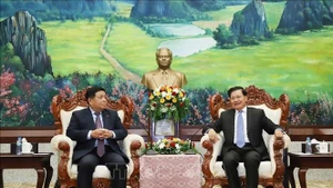 Le secrétaire général et président lao Thongloun Sisoulith et le vice-Premier ministre vietnamien Nguyên Chi Dung (à gauche), lors de leur rencontre à Vientiane, le 9 juillet Photo : VNA.