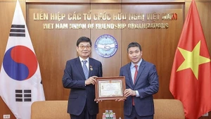 Le président de l’Union des organisations d’amitié du Vietnam, Phan Anh Son (à droite), remet l’insigne « Pour la paix et l’amitié entre les peuples » au président du Conseil d’administration de la société par actions DK ENC Vietnam, Jang Chin Hyuk. Photo : Thoidai.