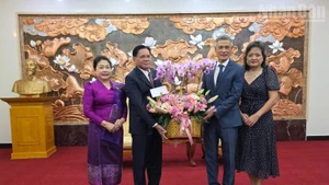 L’ambassadeur Buakeo Phumvongsay et son épouse offrent des fleurs pour féliciter l’ambassadeur Nguyen Minh Vu et son épouse, à l’occasion du 80ᵉ anniversaire de la Révolution d’Août et de la Fête nationale du Vietnam. Photo : NDEL.