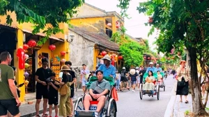 Des touristes dans la vieille ville de Hoi An, au centre du Vietnam. Photo publiée avec l'aimable autorisation du journal Phap luat (Loi).