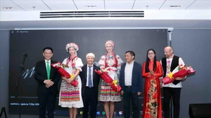 Les délégués offrent des fleurs aux trois auteurs du projet « Le Party au 20e siècle ». Photo : VNA.