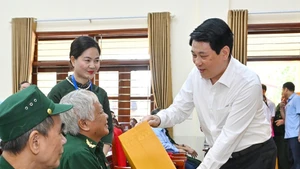 Le président Luong Cuong remet des cadeaux aux invalides de guerre hébergés au Centre de soins aux invalides de guerre de Duy Tien. Photo : NDEL.