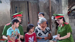 Les agents de la Police communale se rendent auprès des ménages pour sensibiliser et guider la population dans l’accomplissement des démarches administratives en ligne, contribuant ainsi à la mise en œuvre efficace du projet 06 du gouvernement. Photo : Trong Duc/VNA.