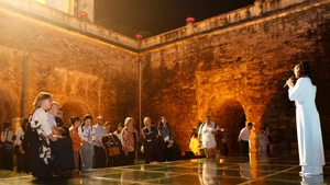 Des visiteurs étrangers vivent une expérience unique en découvrant la Citadelle impériale de Thang Long lors d’une visite nocturne. Photo : Hanoimoi.