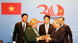 Le président vietnamien Luong Cuong (au milieu) assiste à la cérémonie de restitution des souvenirs de guerre aux vétérans américains et à leurs familles. Photo : NDEL.