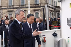 Le roi Frederik X de Danemark invite le secrétaire général du PCV et président de la République, To Lam, à monter à bord d’un bateau pour visiter l’île artificielle de Lynetteholm, actuellement en cours de construction. (Photo : VNA)