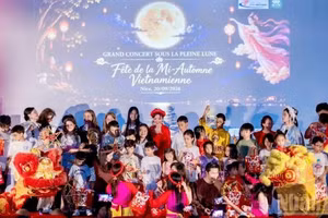 Des enfants montent sur scène pour participer à la procession des lanternes de la fête de la mi-automne aux côtés de la Fée de la Lune, de Chu Cuoi et des lions-dragons, et recevoir des cadeaux des organisateurs. (Photo : KHAI HOAN)